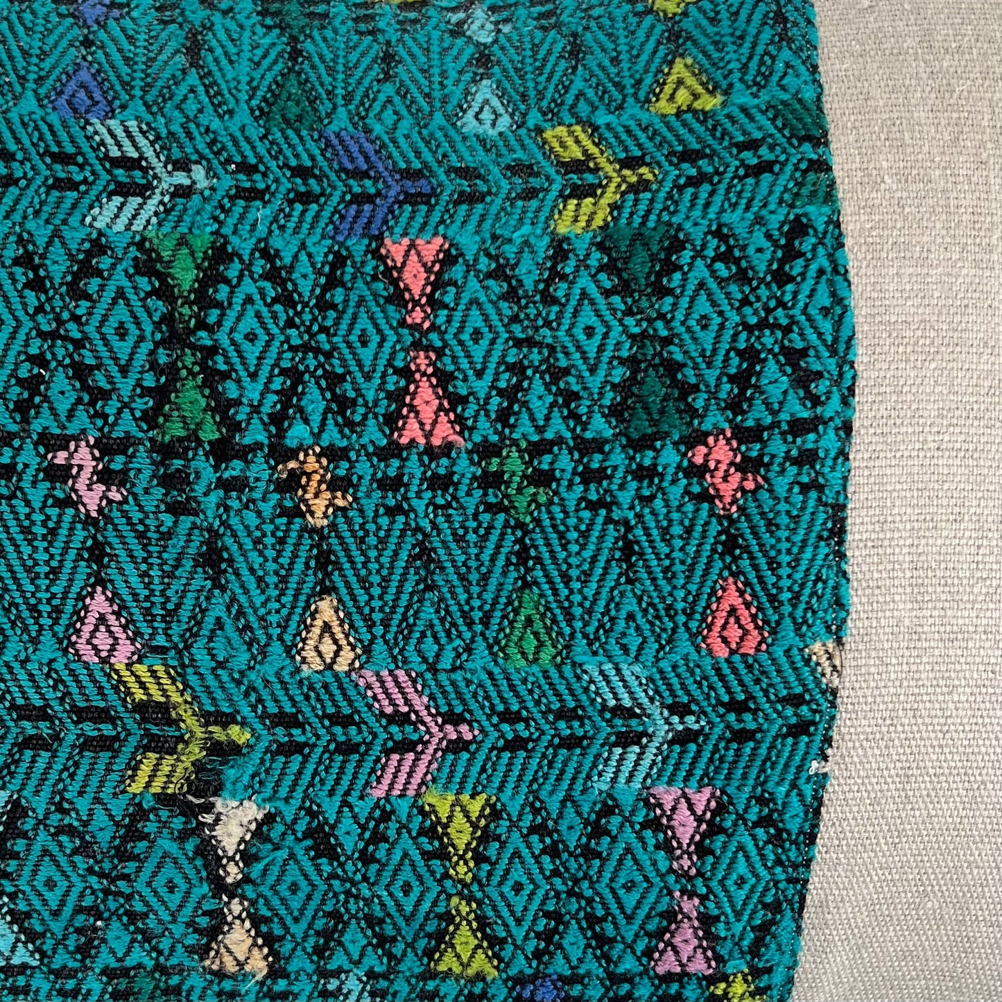 Close up of Green Huipil and Hemp Pillow on a light gray background - Intertwined: Handmade for Good