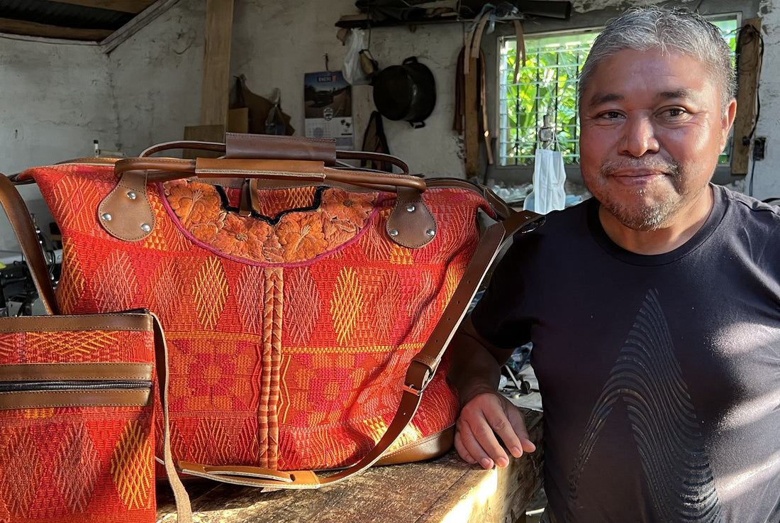 Lorenzo next to an orange Huipil Weekender bag, made for Intertwined for Good in his leather workshop in Guatemala.