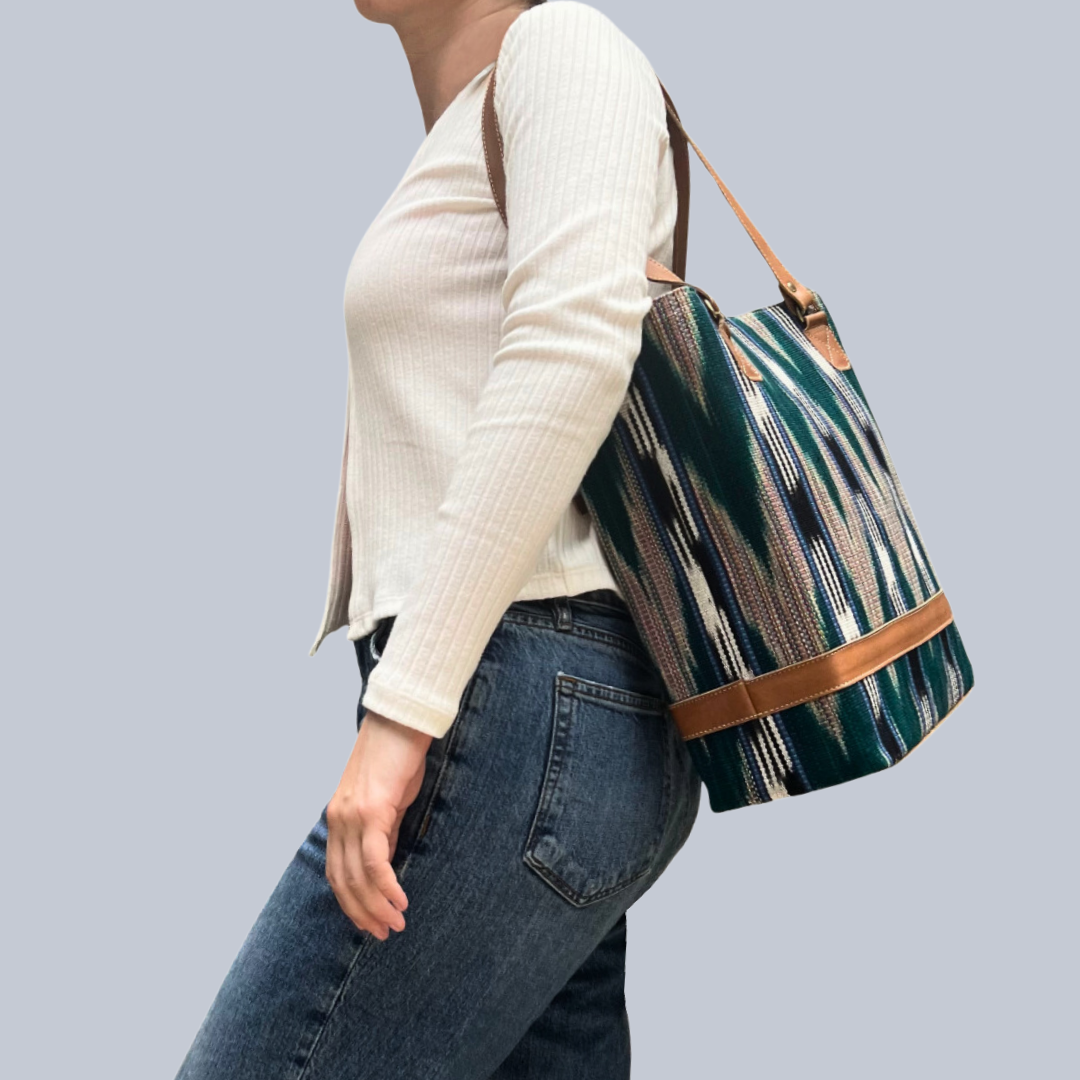 Model wearing Intertwined: Handmade for Good's dark green and navy Jaspe Structured Tote over shoulder.