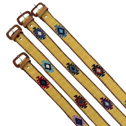 Two yellow belts with decorative patterns and brown buckles on a white background
