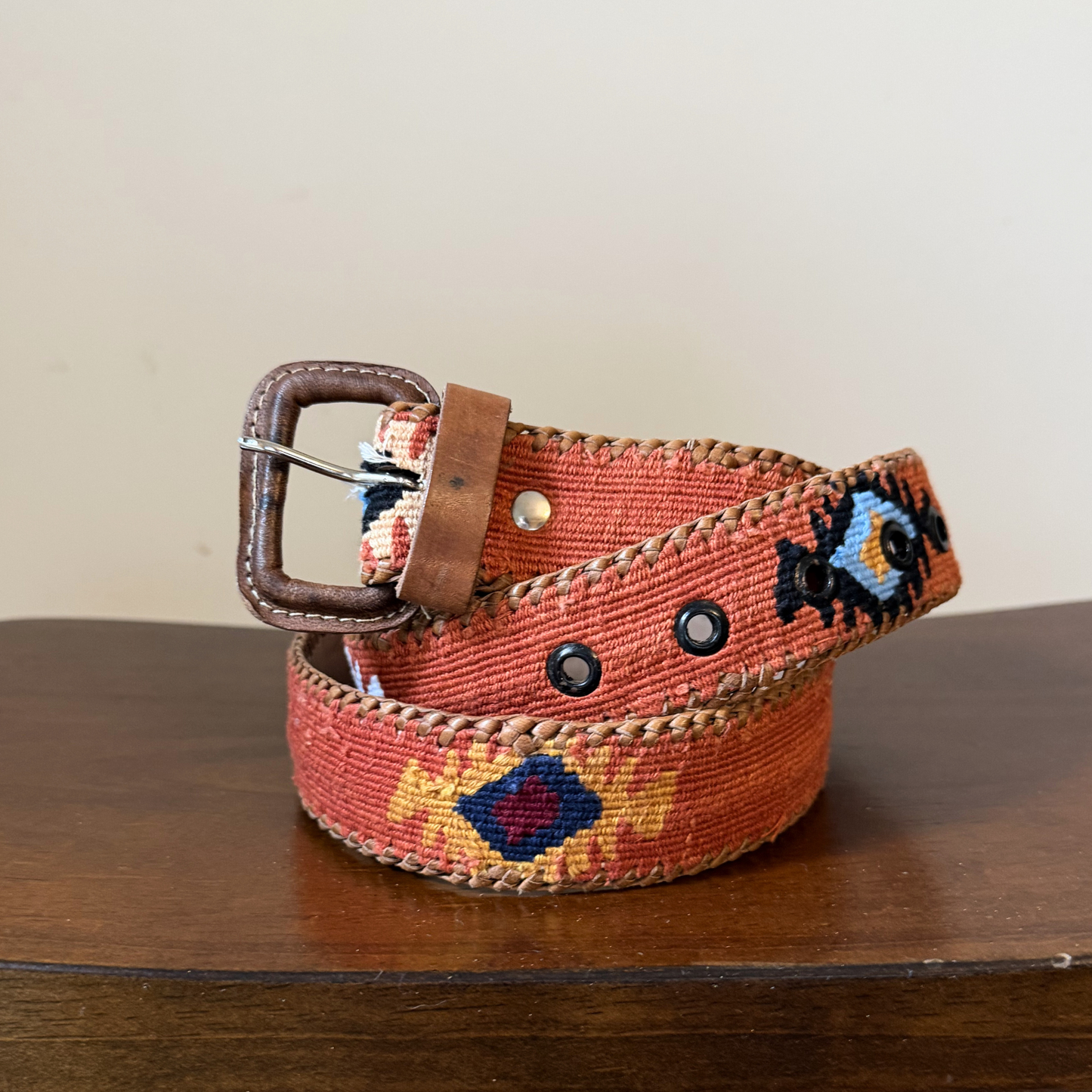 Colorful belt with a brown buckle on a wooden surface