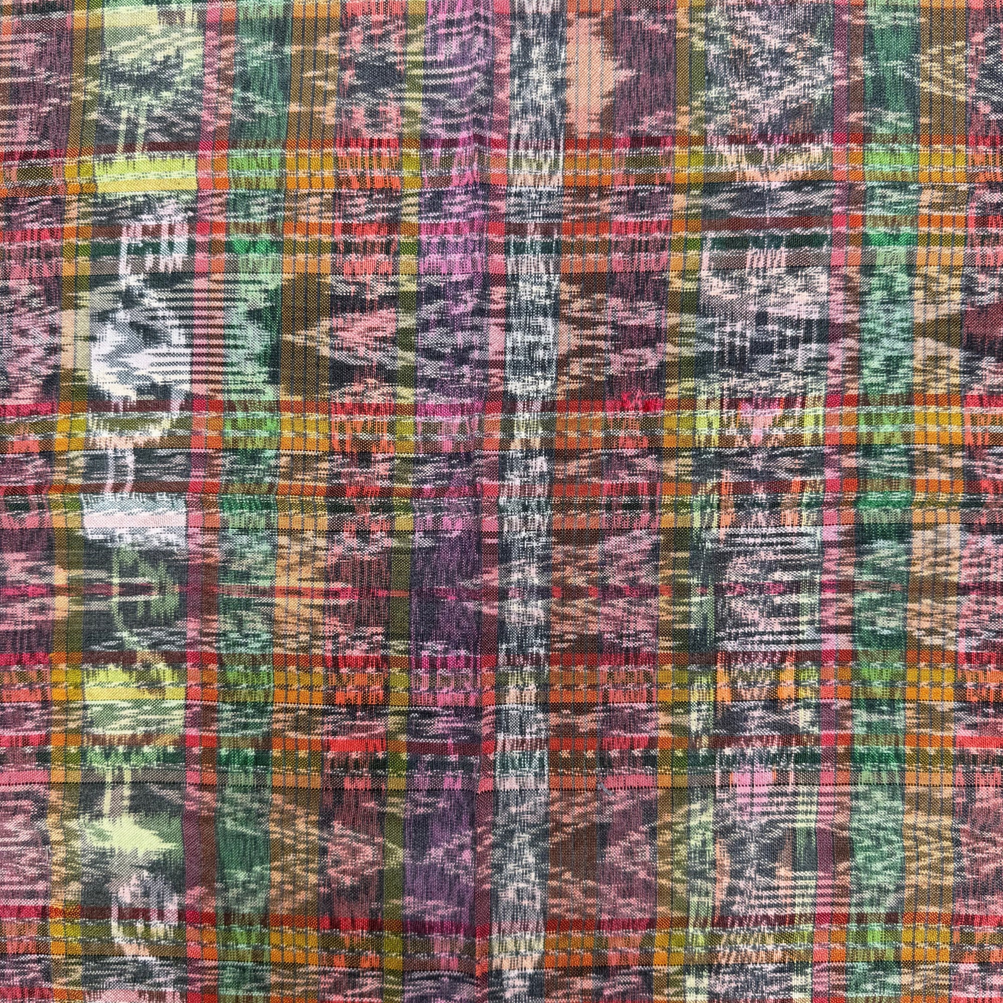 A close-up of a multicolor plaid fabric with vertical stripes in shades of purple, green, orange, pink, yellow, and black.