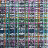 A close-up of a woven fabric with a multicolor plaid ikat pattern featuring shades of blue, green, pink, orange, and black.