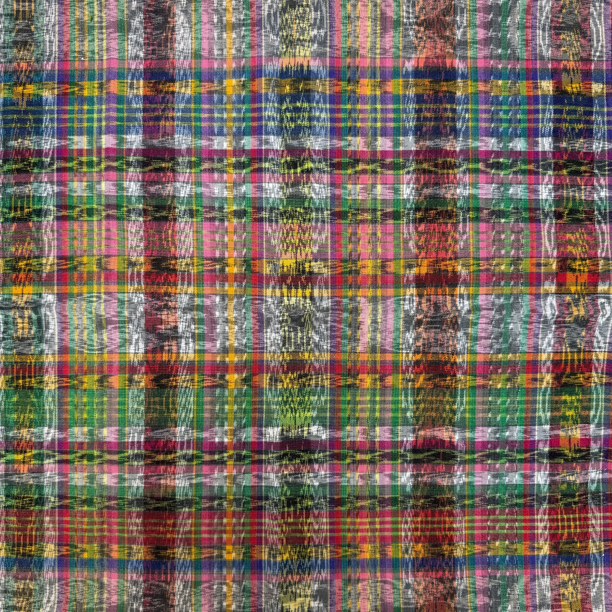 A close-up of a multicolored plaid ikat fabric pattern with vertical wavy stripes in pink, green, blue, yellow, red, and white.