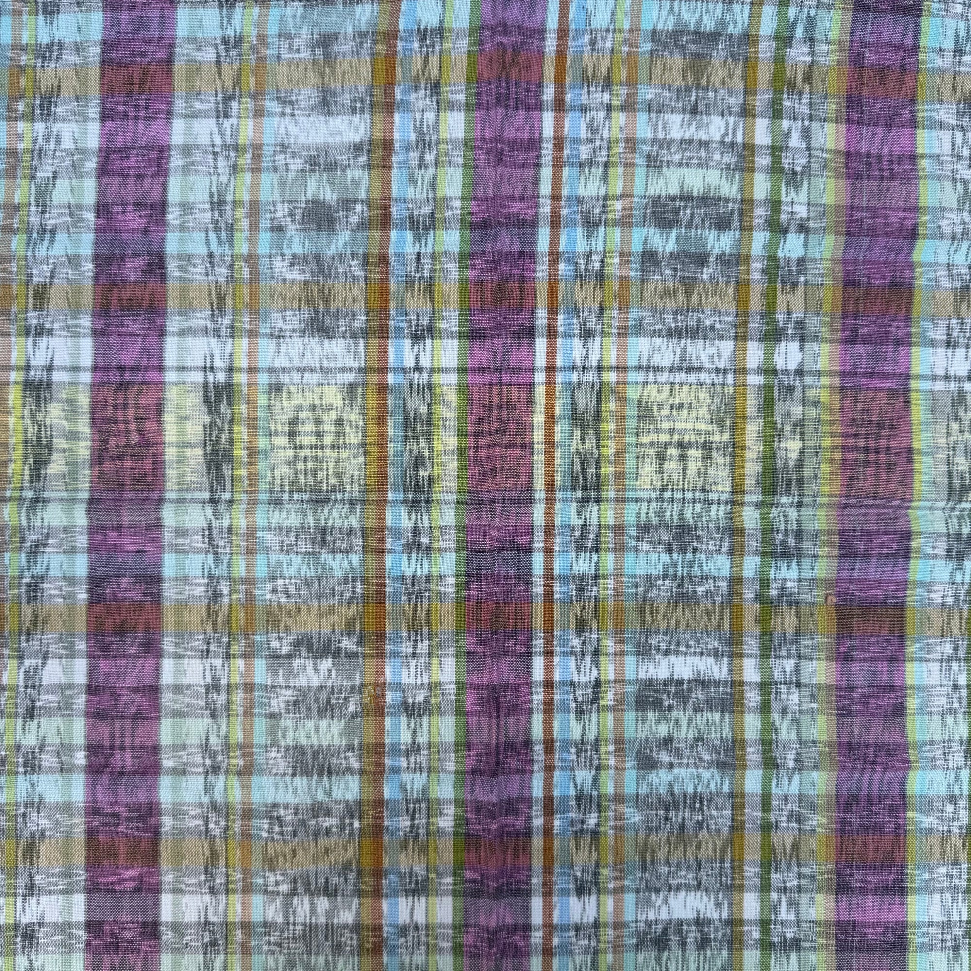A close-up of a plaid ikat fabric pattern with vertical stripes in purple, light blue, olive green, mustard yellow, and black.