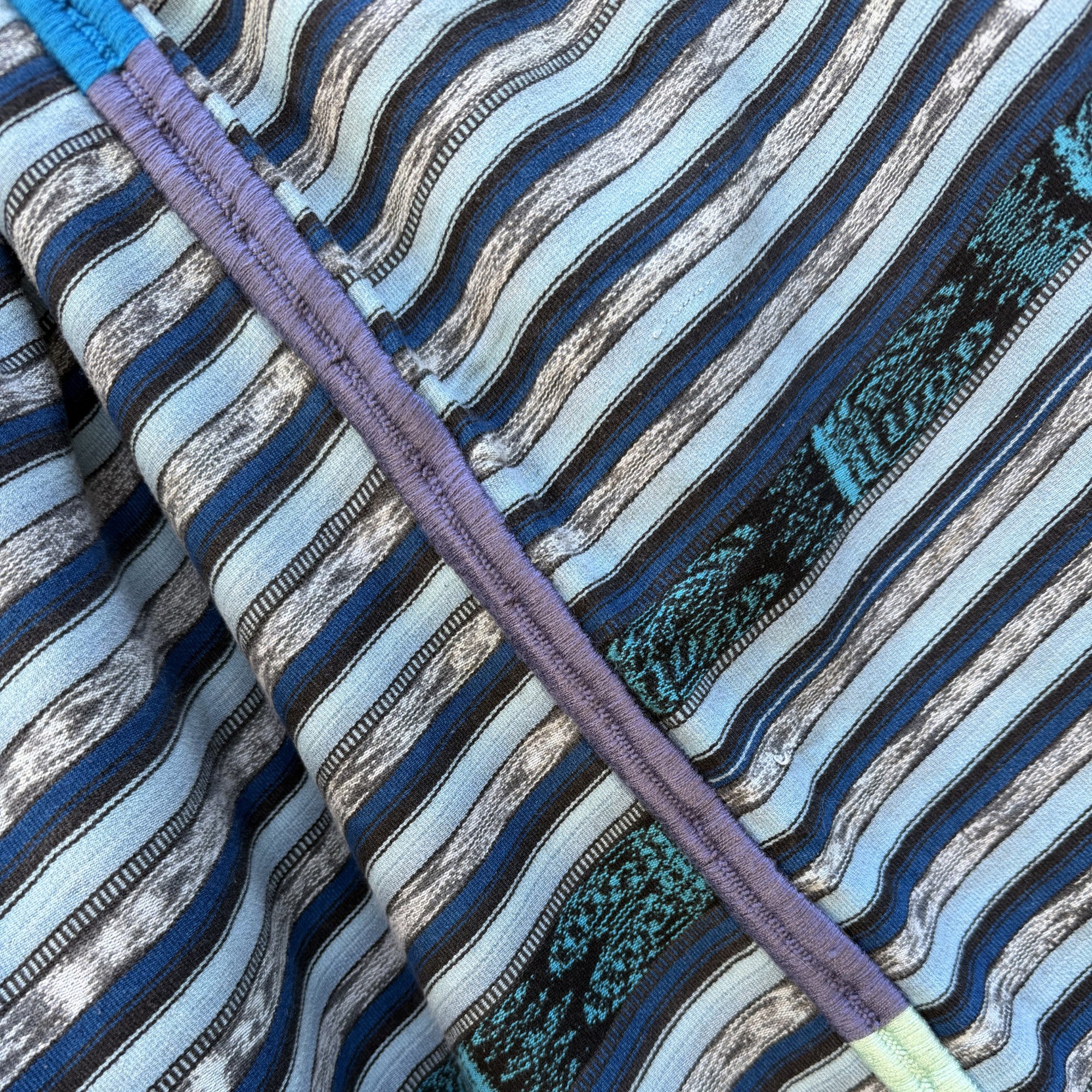 Close-up of fabric with blue, gray, and green striped pattern