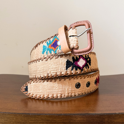 Woven belt with floral patterns on a wooden surface