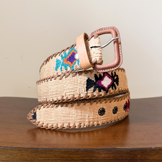 Woven belt with floral patterns on a wooden surface