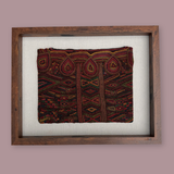 Framed textile with intricate patterns on a plain background