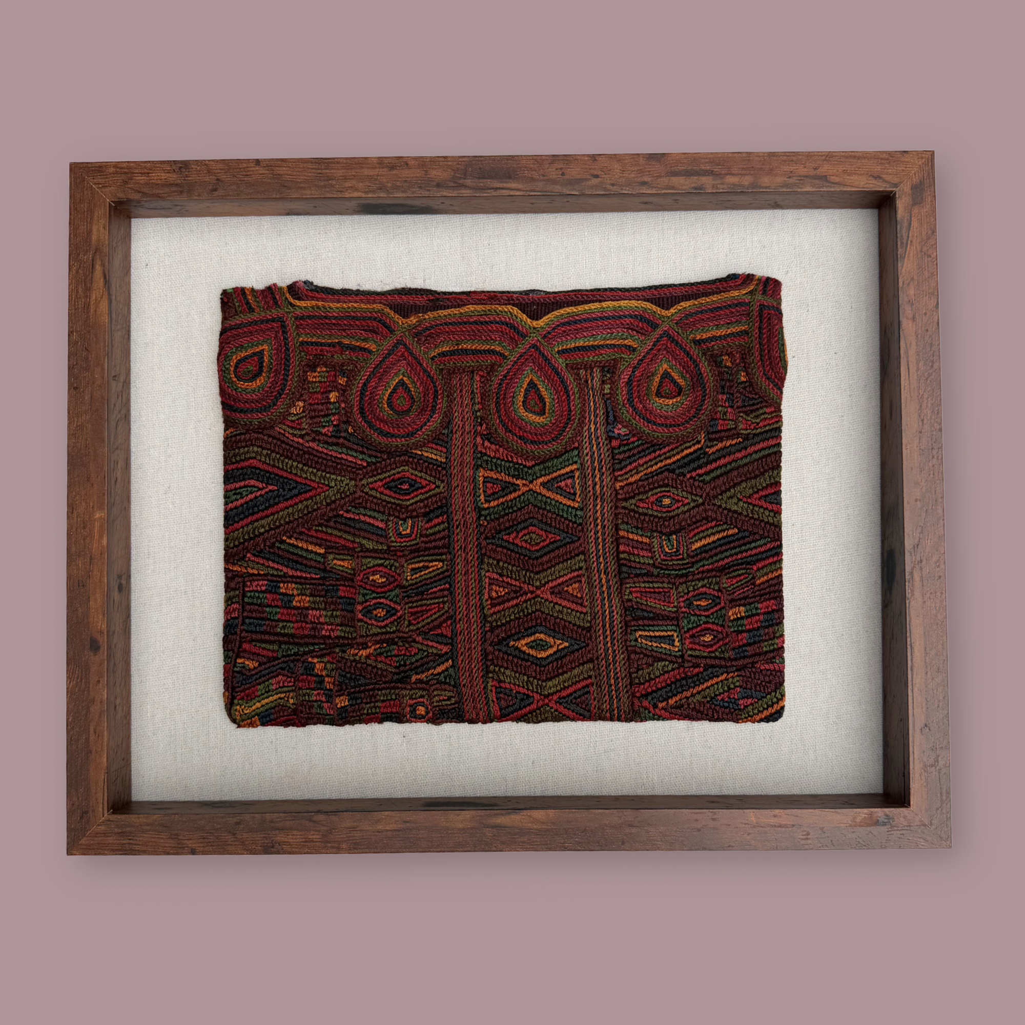 Framed textile with intricate patterns on a plain background