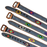 Five denim-style belts with brown leather buckles and trim, decorated with colorful geometric beadwork, arranged diagonally on a white background.