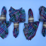 Colorful plaid napkins with gold rings on a blue background