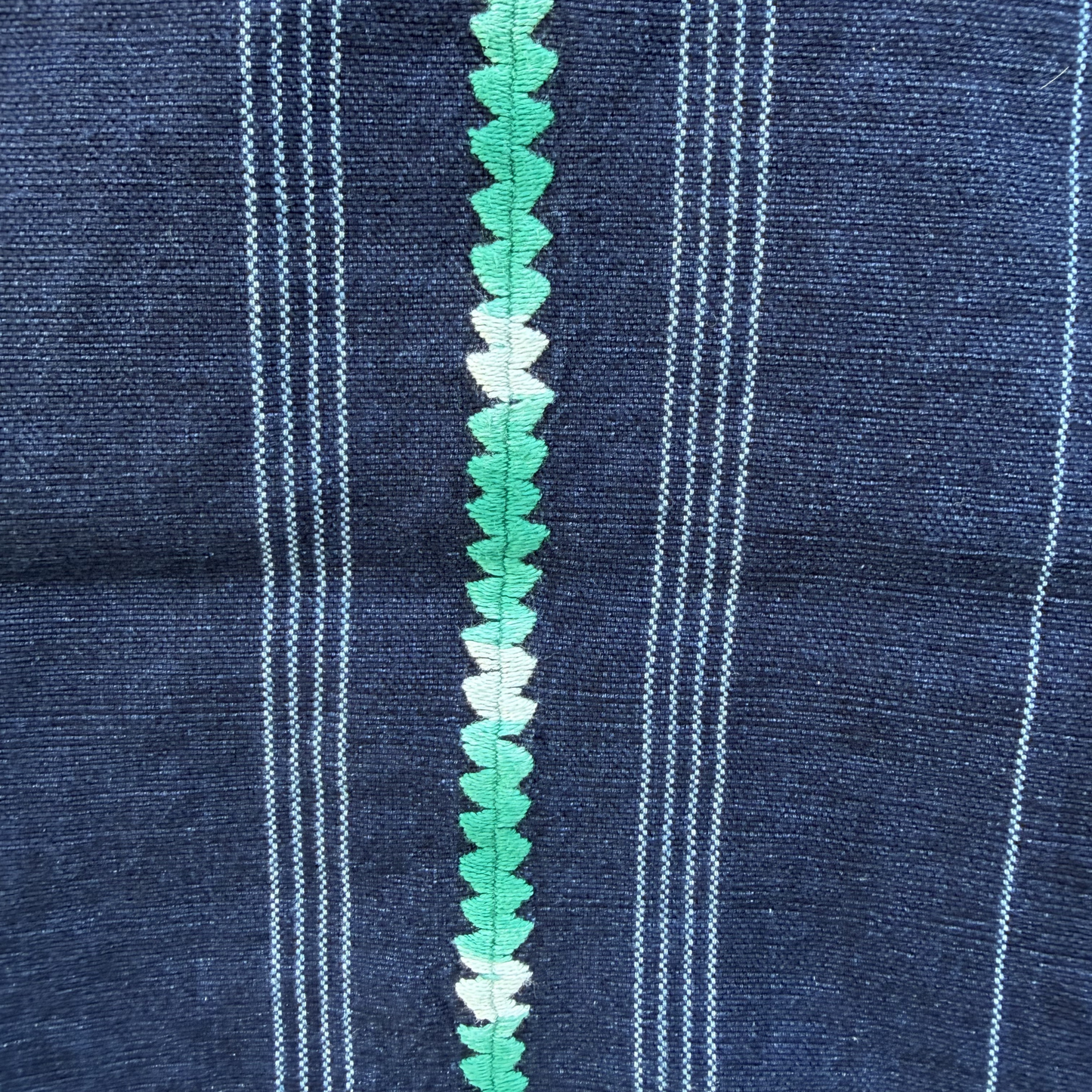 Close-up of blue fabric with green decorative trim