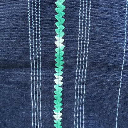 Close-up of blue fabric with green decorative trim