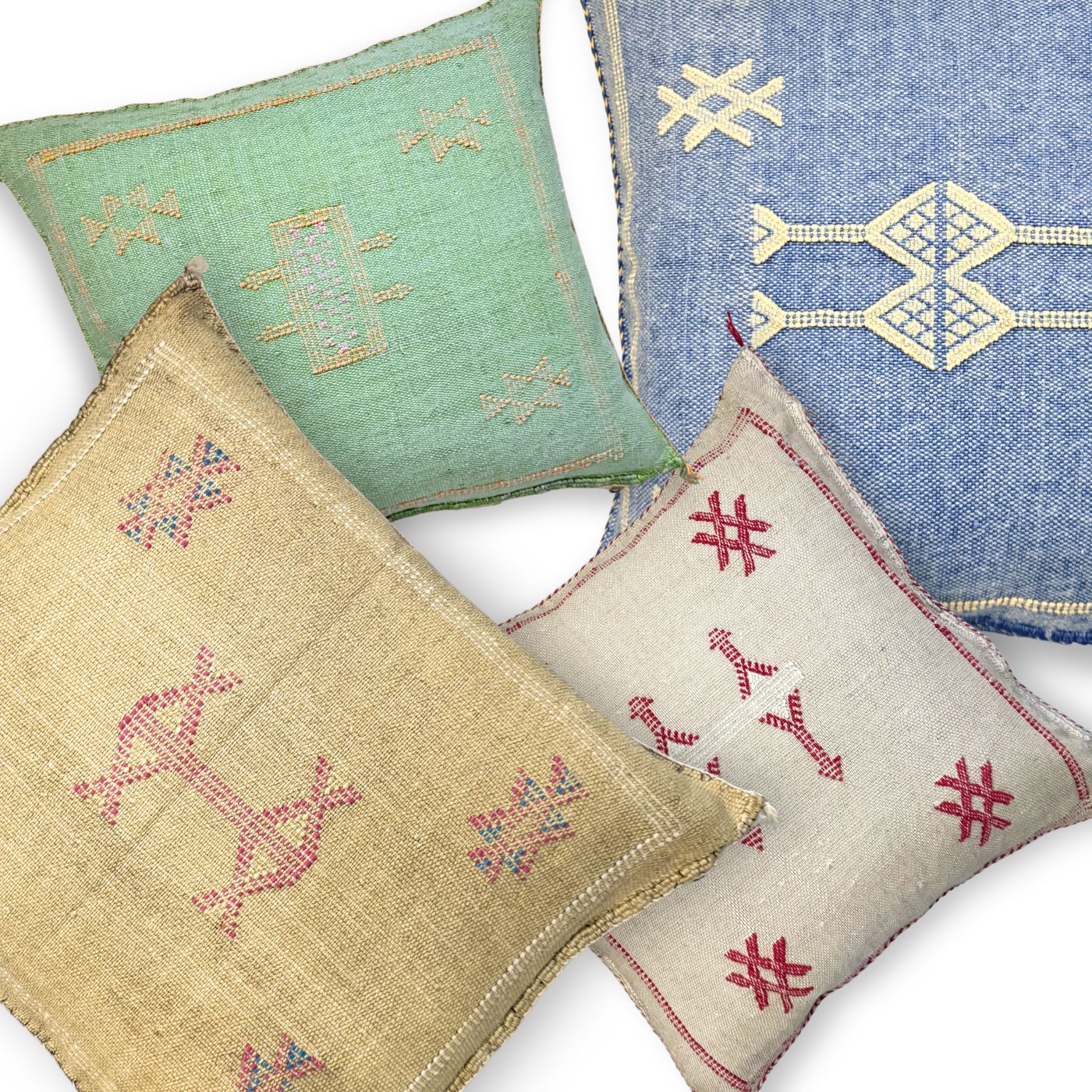 Four embroidered sabra cactus silk cushions in different colors on a white background