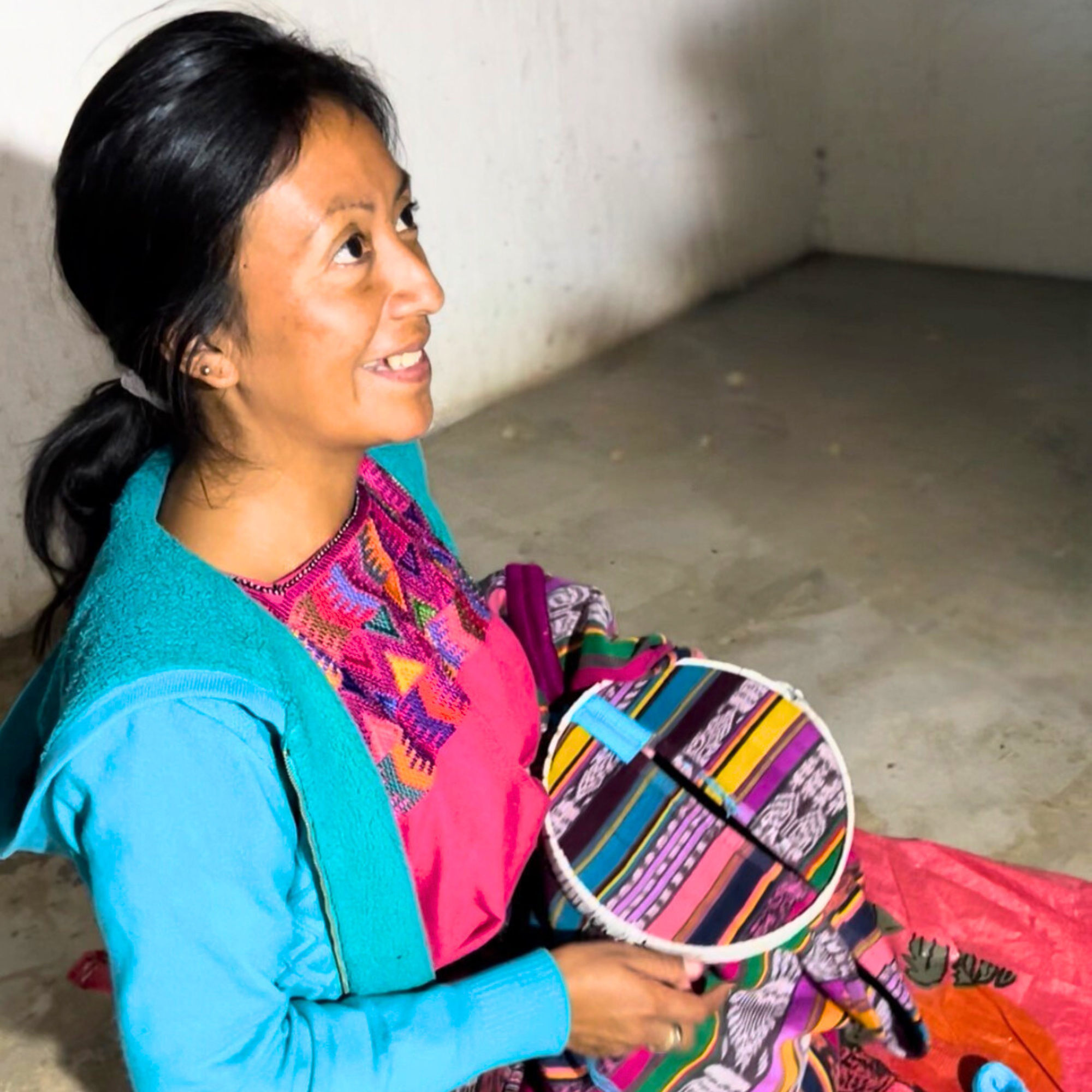Tomasa explains how she makes the randa embroidery on a cotton corte blanket.