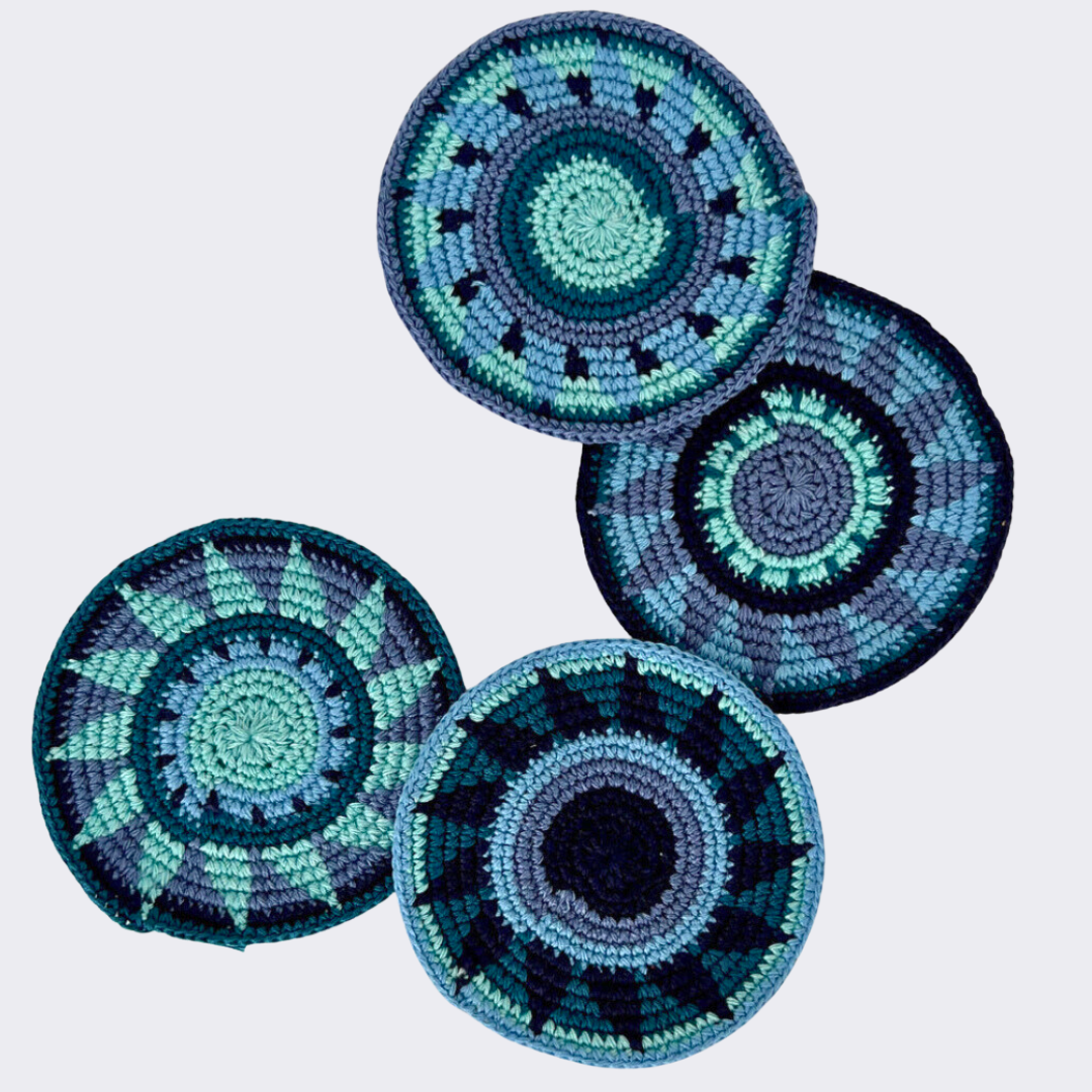 Blue and black crocheted coasters on a light gray background - Intertwined: Handmade for Good