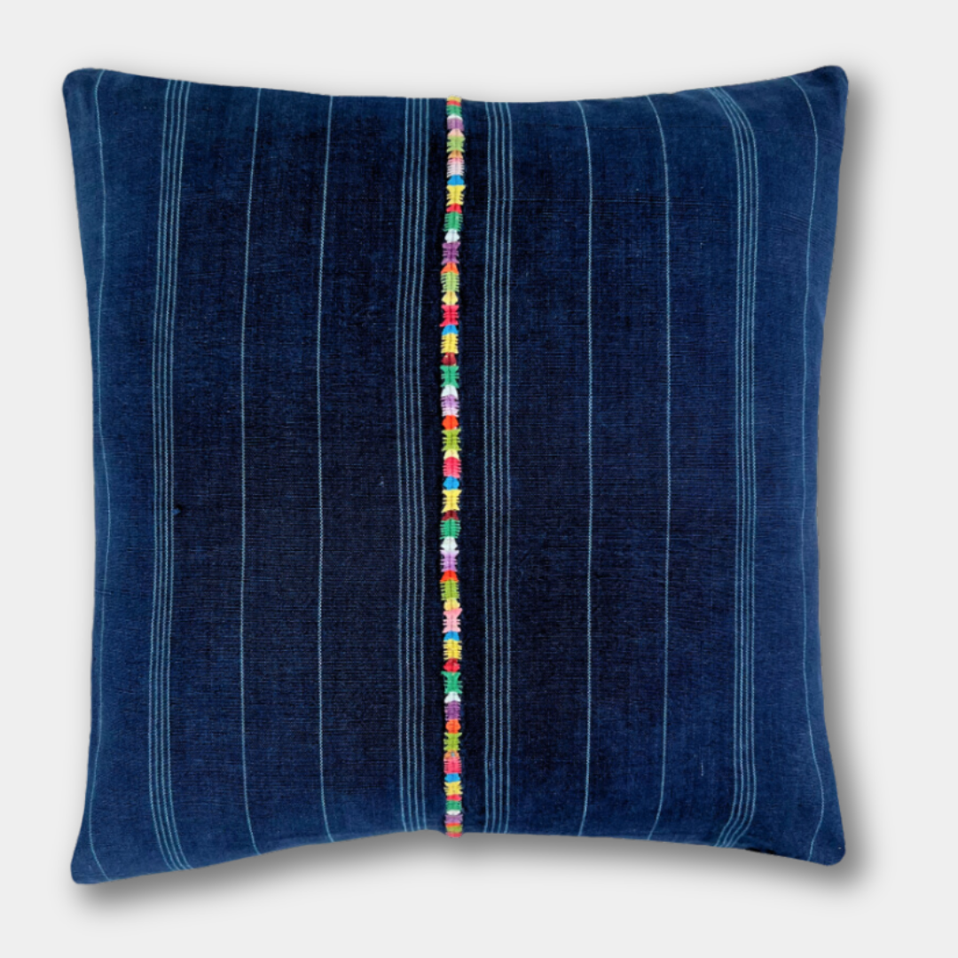 Indigo Corte Pillow on a light gray background with a multicolor embroidered stripe down the middle.
