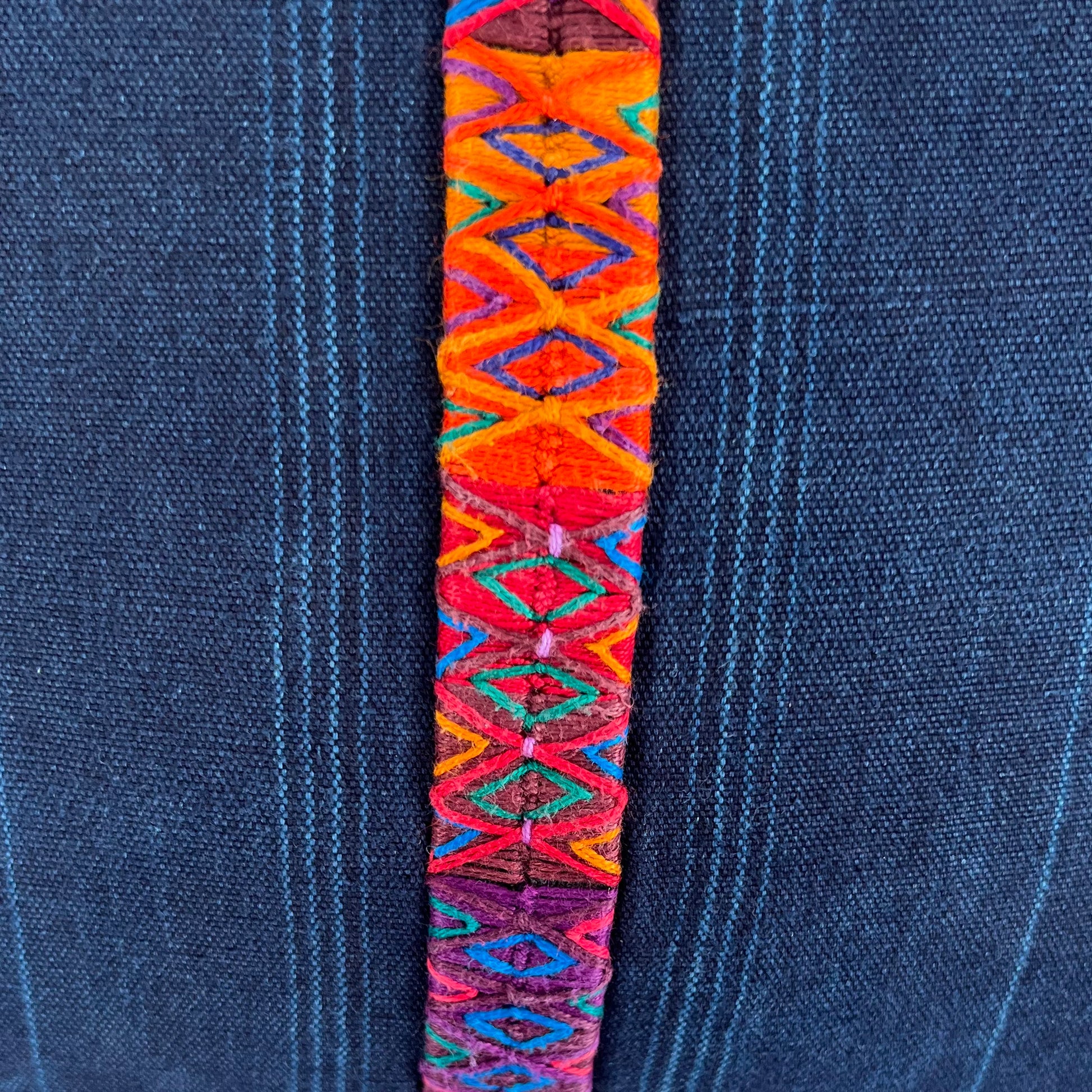Close up of multicolor stripe down middle of indigo corte pillow.