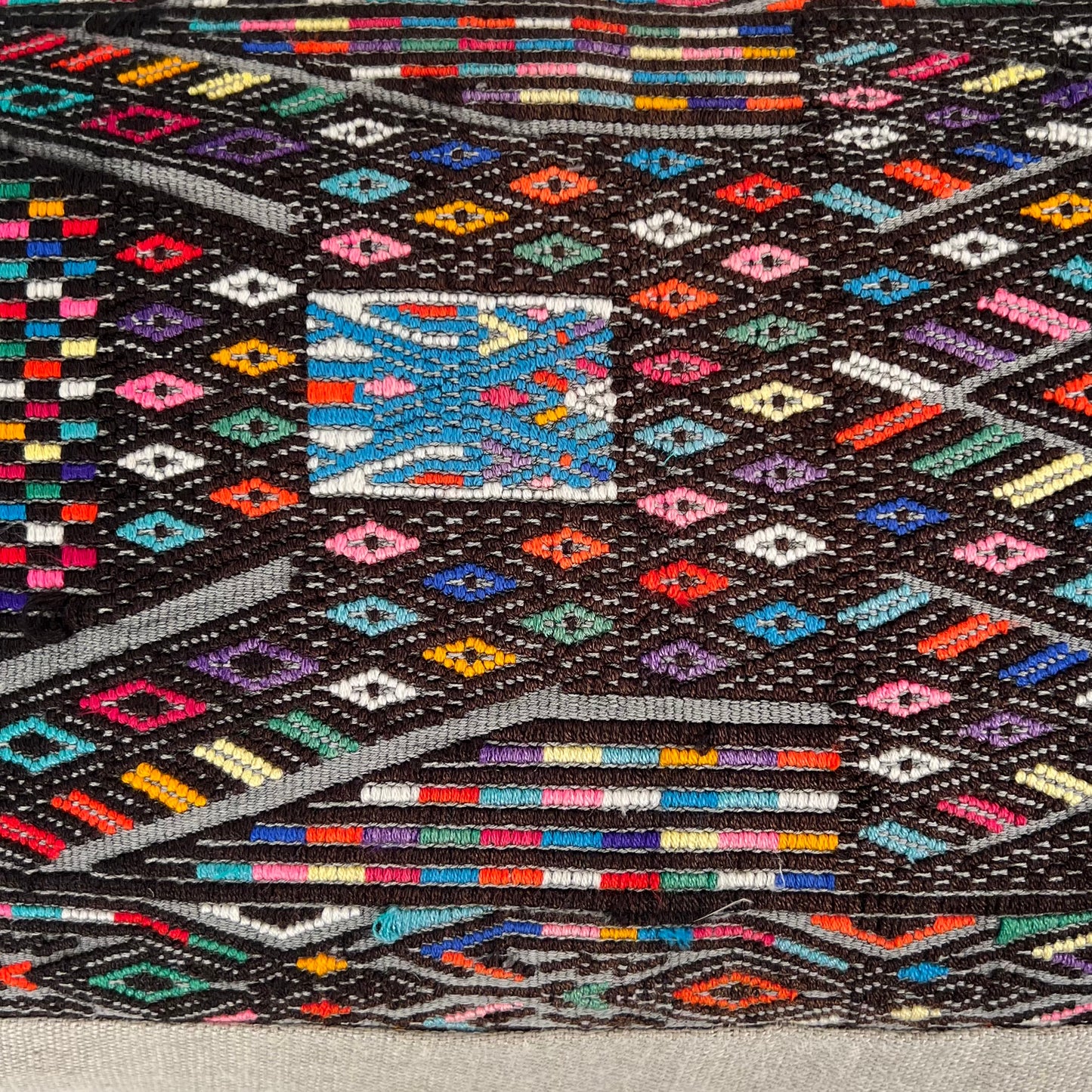 Close up of Black multicolor Huipil and Hemp Pillow on light gray background - Intertwined: Handmade for Good