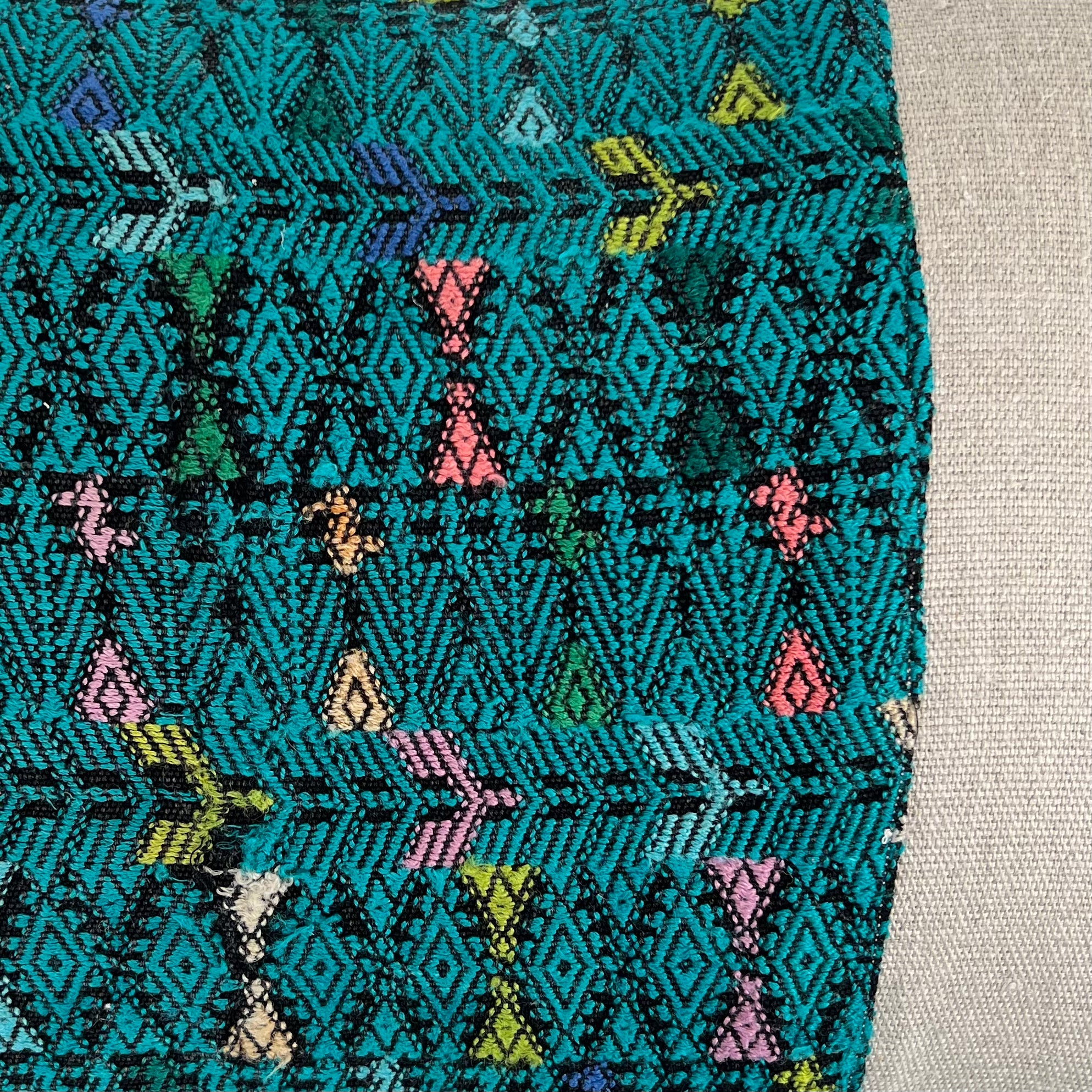 Close up of Green Huipil and Hemp Pillow on a light gray background - Intertwined: Handmade for Good