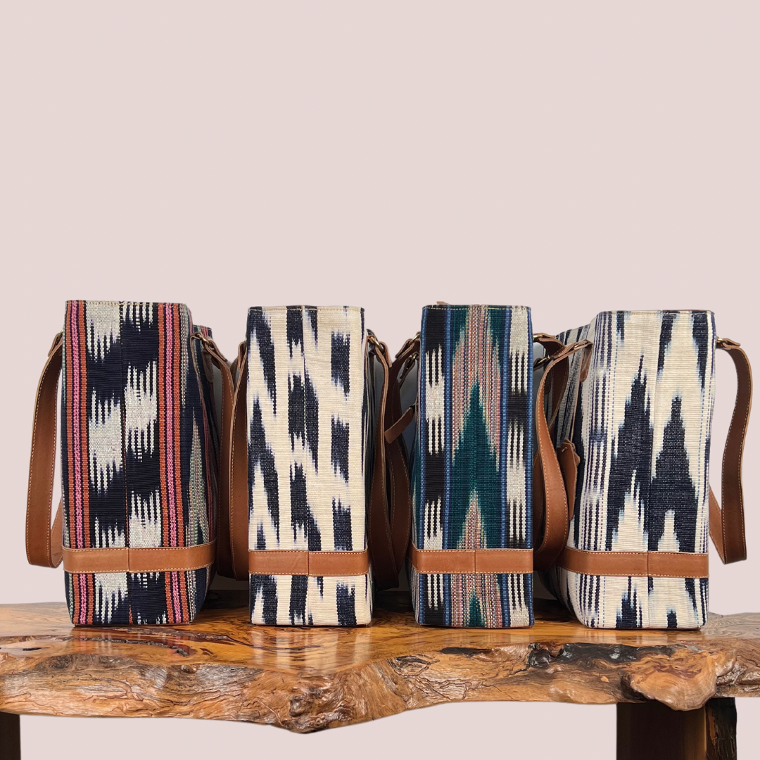 Intertwined: Handmade for Good's four color variations of the Jaspe Structured Tote, lined up on a bench display.