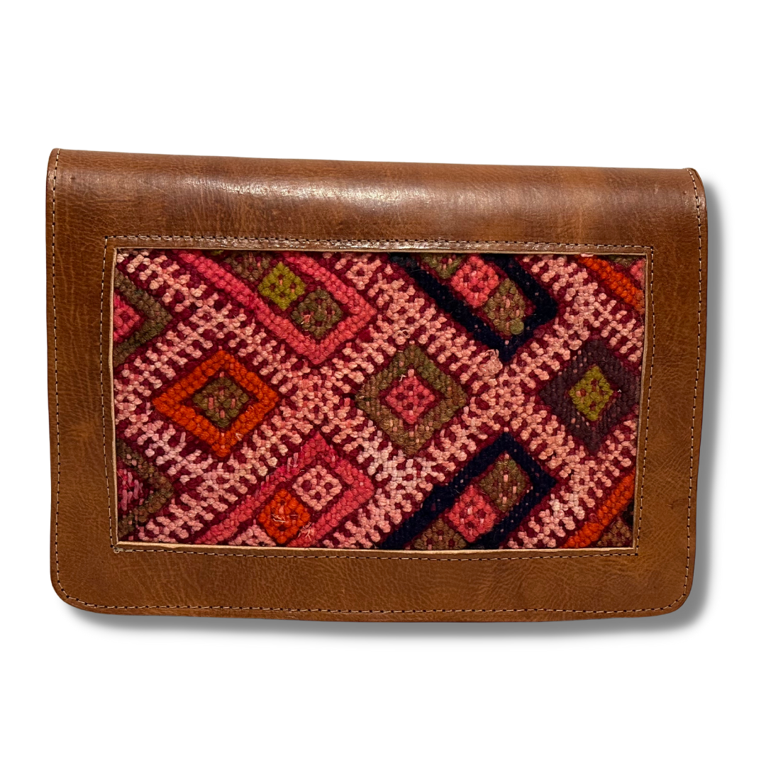 Intertwined: Handmade for Good's Kilim Front Crossbody. Primarily pink with red, green and black accents. 