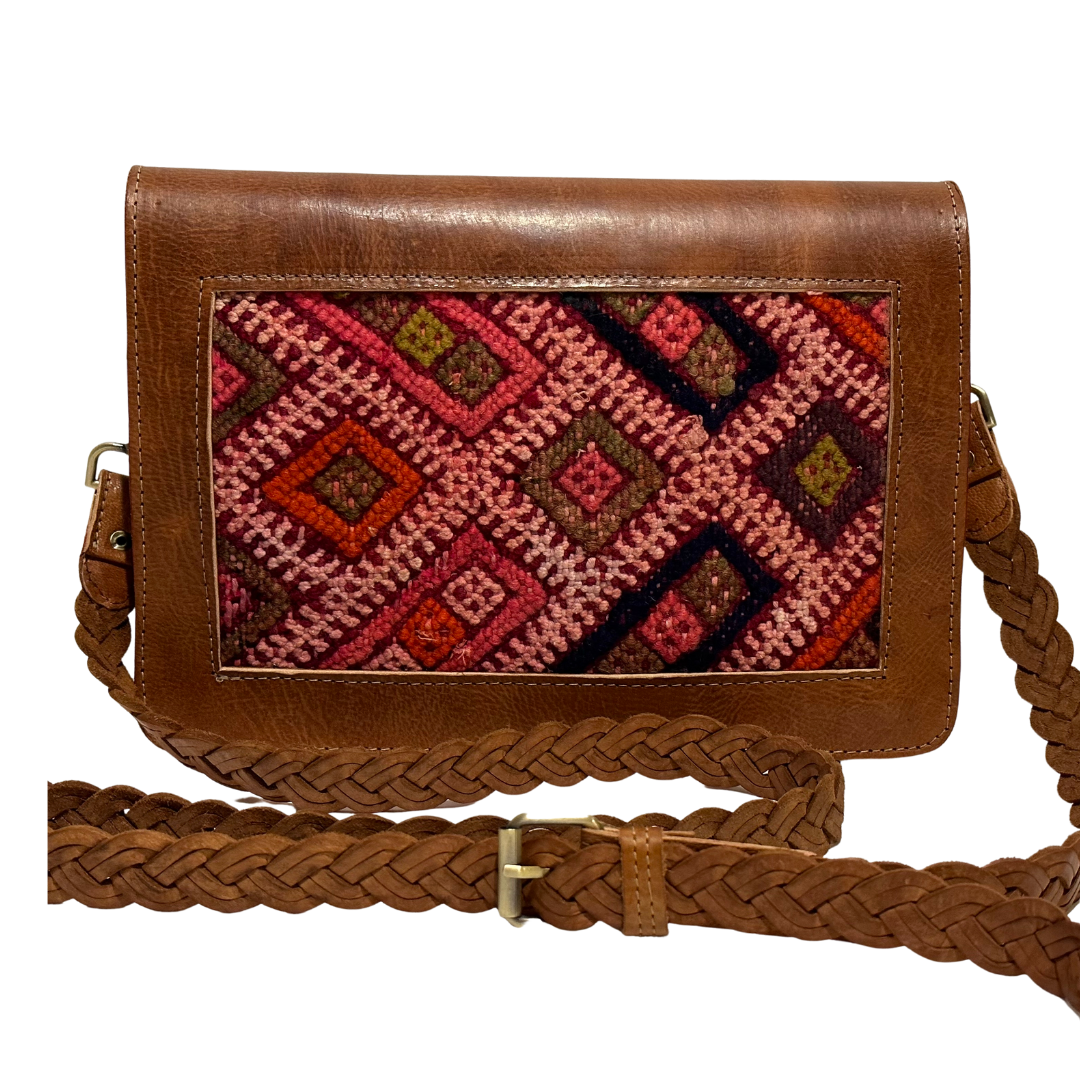 Intertwined: Handmade for Good's Kilim Front Crossbody with adjustable shoulder strap. Primarily pink with red, green and black accents.